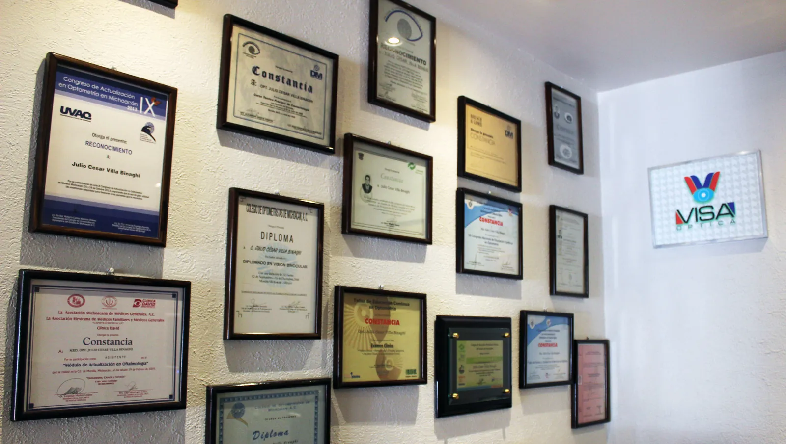 Pared con diplomas y constancias de actualización en optometría